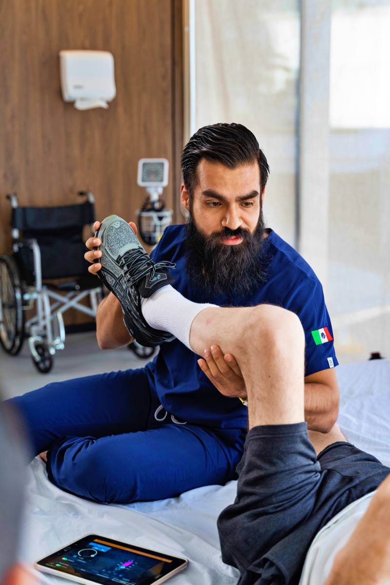 Verita Neuro Epidural Stimulation PT with tablet showing patient undergoing physical therapy while being monitored on tablet